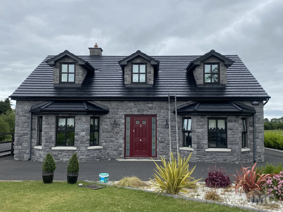 A stone-fronted house with a newly sealed roof