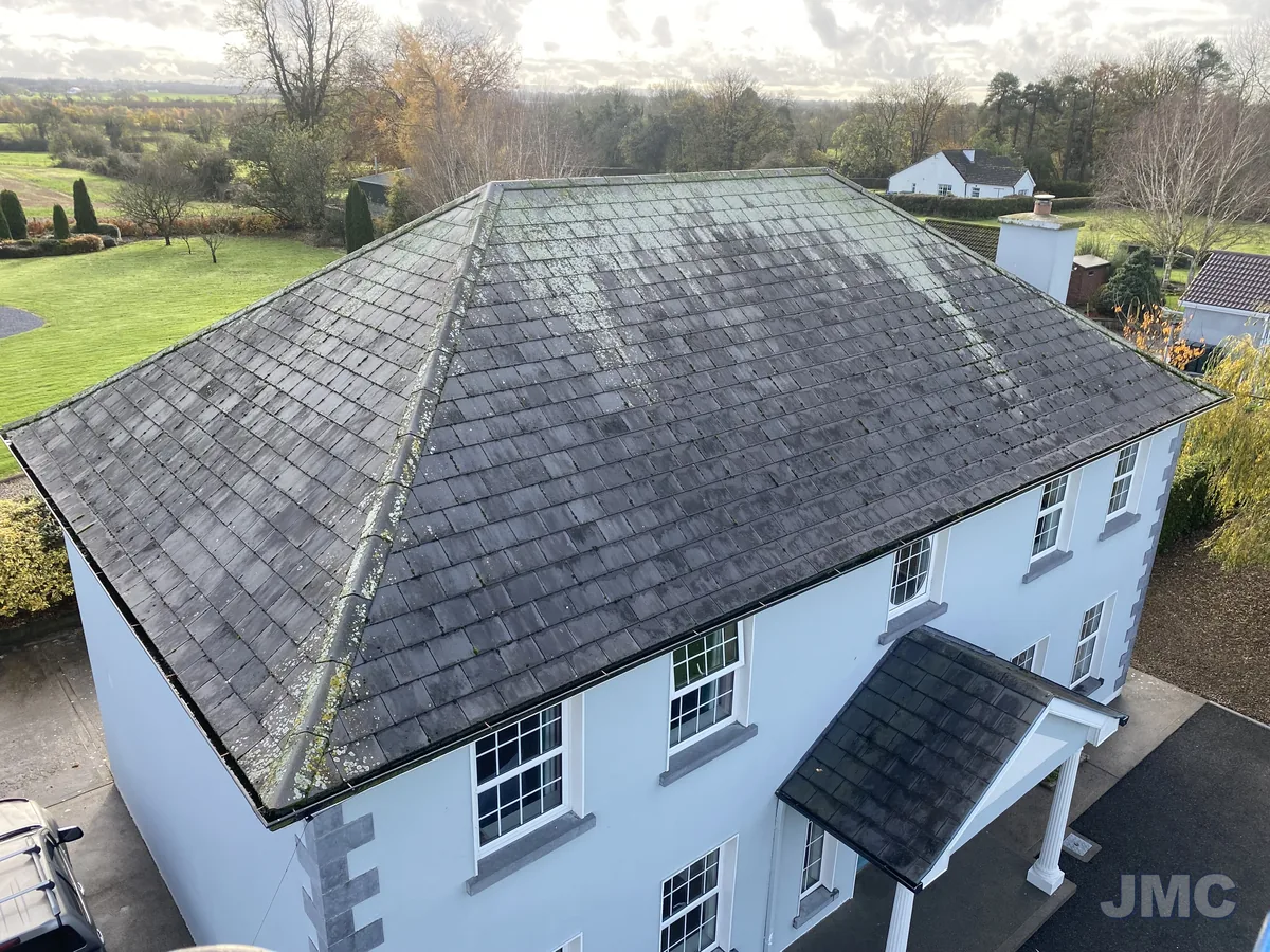 Before: Hipped slate roof, moss and lichen removed