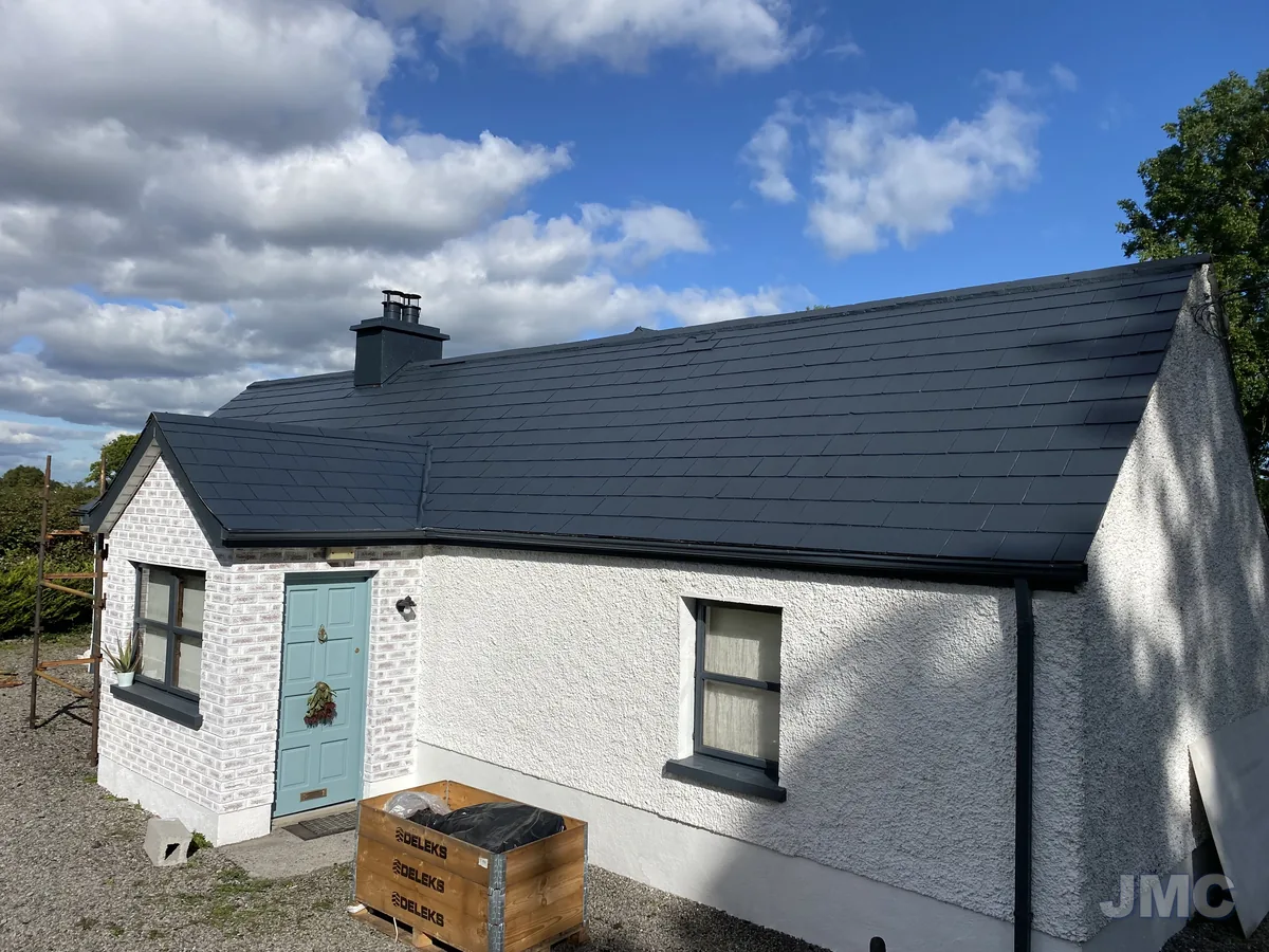 After: Cottage roof coated black, walls washed